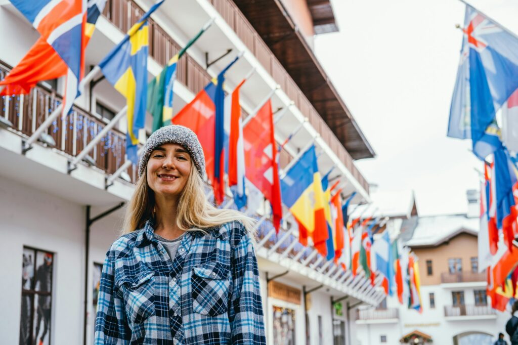 Outdoor portrait young woman standing on a square with a lot of government flags.